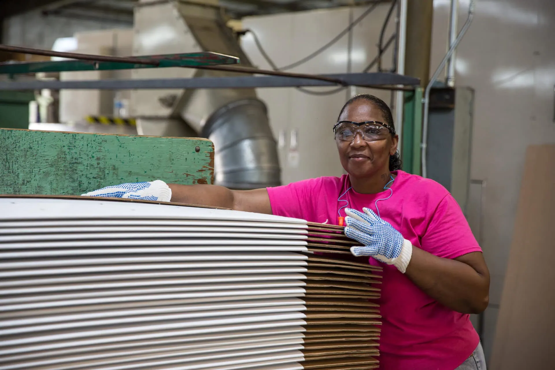 Image of Express Packaging Employee next to a stack of cardboard boxes