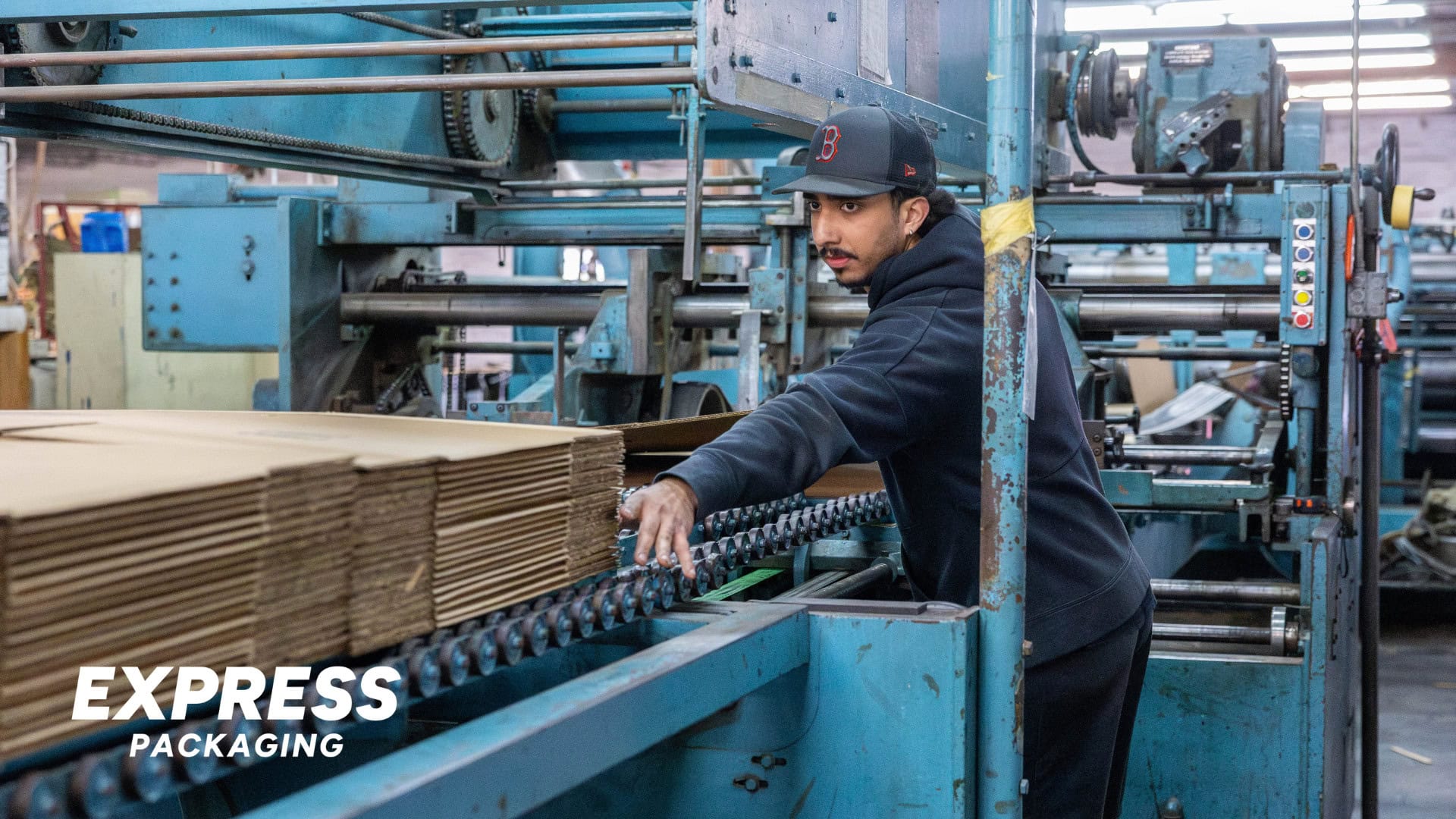 Man feeding in cardboard boxes in machine