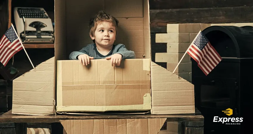 boy playing in Cardboard Box american flag