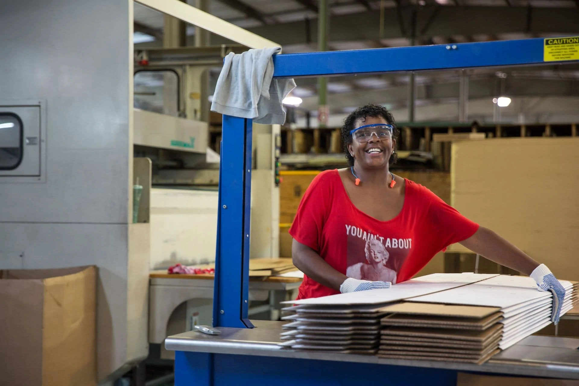 happy factory employee moving cardboard boxes