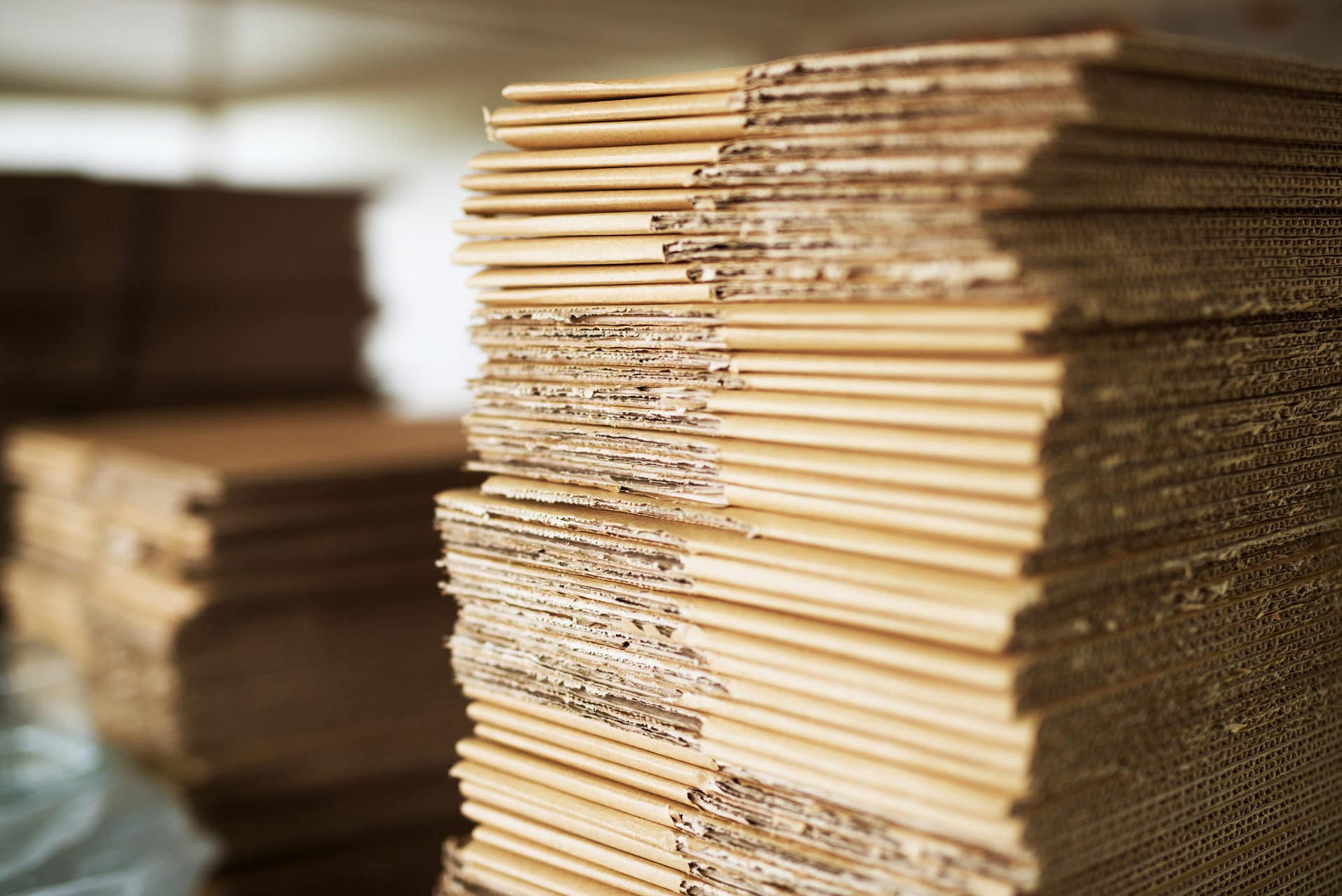 Big stack of brown boxes placed near the factory production line.